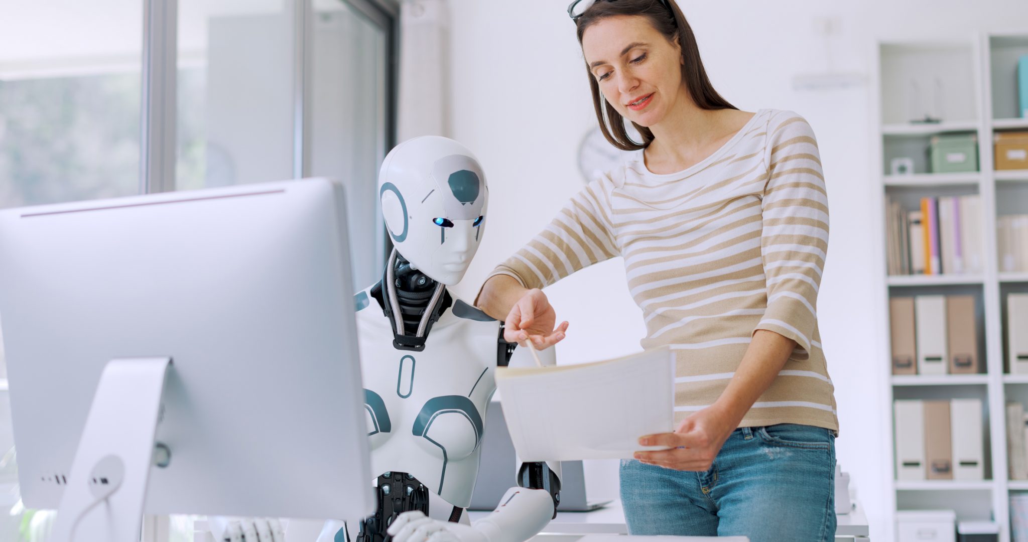 Woman and AI robot working together in the office, automation and technology concept